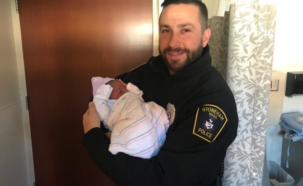 Stoneham Police Officer Michael Colotti holding the baby he helped deliver on Thanksgiving (Stoneham Police/Courtesy Photo)