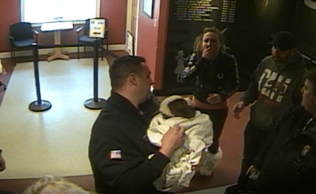 Megan Vitale (second from left) reacts as her puppy, Bodhi, is revived by police officers and firefighters. (North Reading Police Department Surveillance Image)
