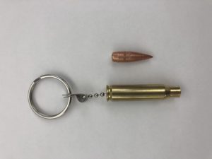 The real slug (top) was attached to an empty brass casing and made into a keychain that was owned by a student at the Byam Elementary School in Chelmsford. Officials have discussed the appropriateness of such a keychain with the student after the slug broke off on Wednesday and was found on a sidewalk outside the school by a custodian. (Chelmsford Police Department/Courtesy Photo)